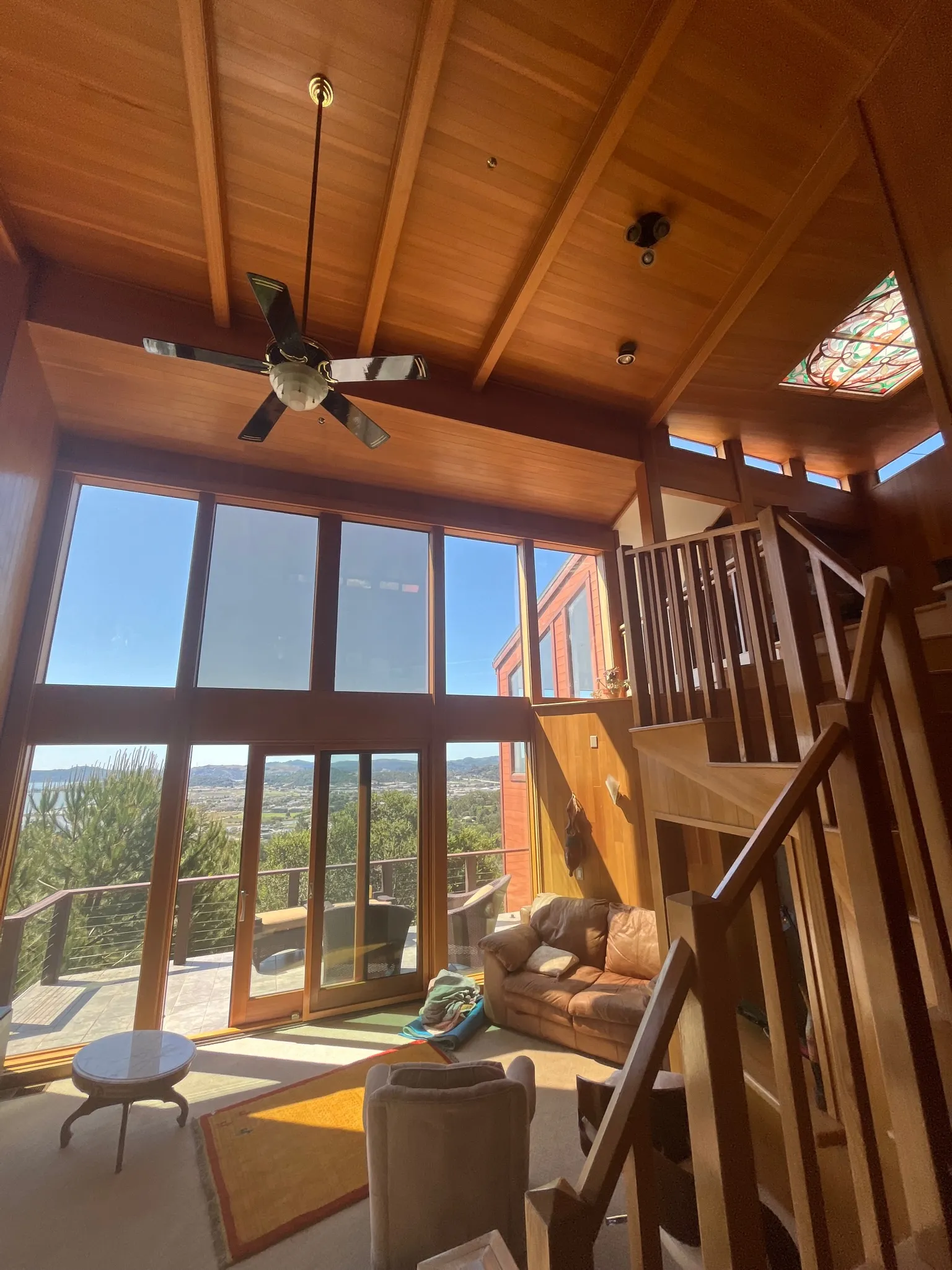 A great room with a vaulted cedar ceiling and floor-to-ceiling windows over the valley
